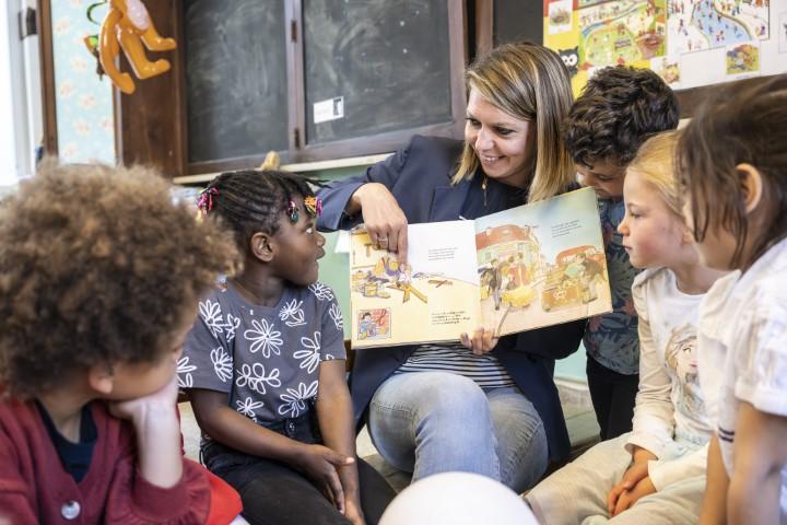 Leerkracht leest boek voor aan de klas in stedelijke basisschool de horizon